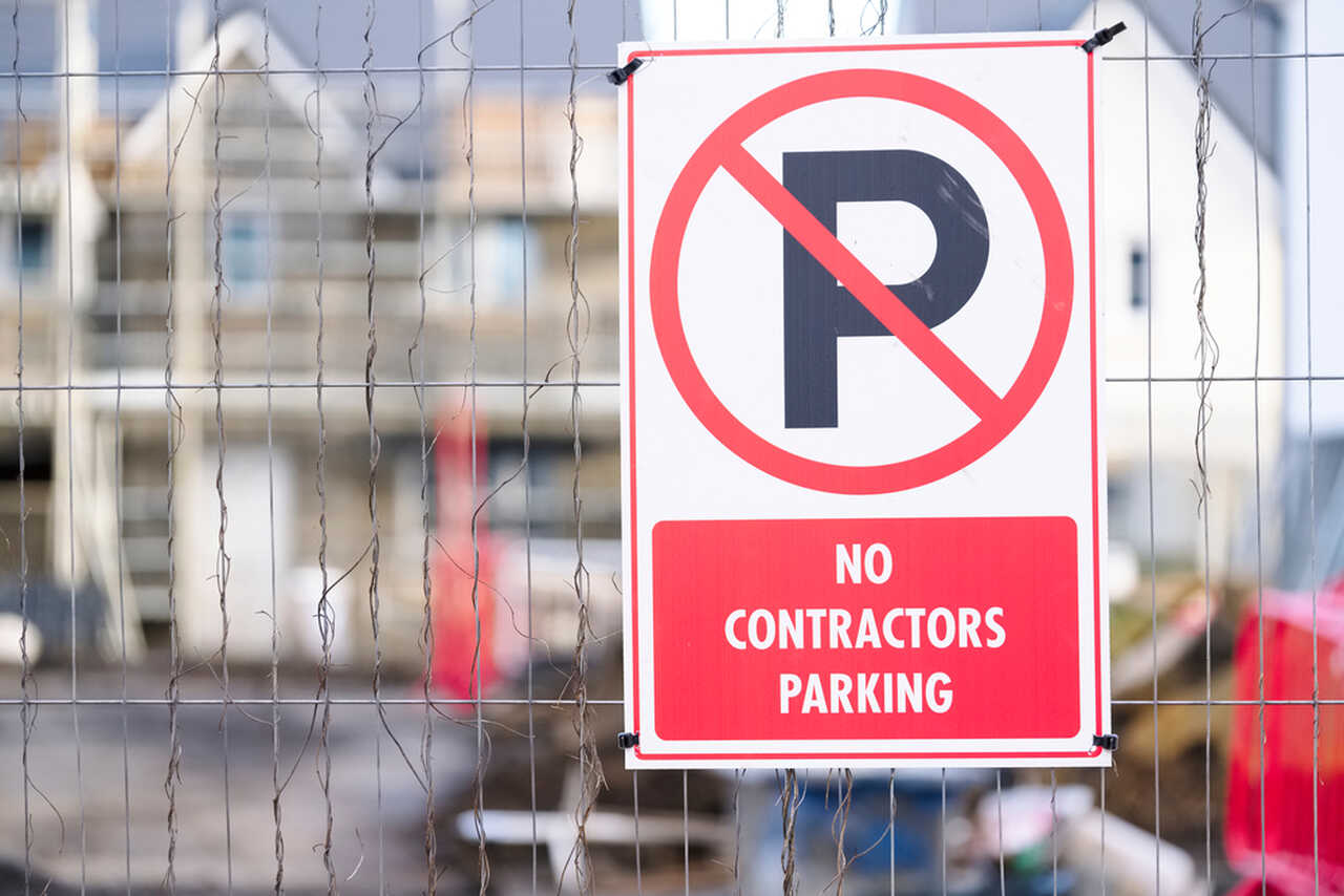 No parking sign for contractors at construction site.